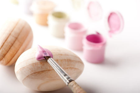 Painting with brush over wooden Easter eggs の写真素材