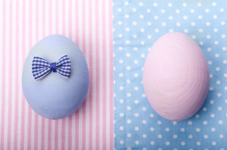 Blue and pink eggs on stripped and dotted napkins with little bowの写真素材