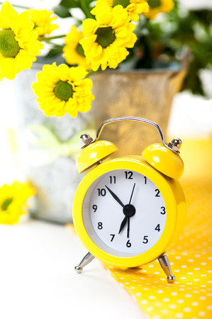 Yellow alarm clock and tin bucket flowersの写真素材