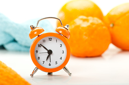 Alarm clock with oranges and blue napkinの写真素材