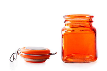 Empty orange glass jar with lid isolated on whiteの写真素材