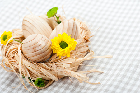 Three wooden eggs in nest on grey napkinの写真素材