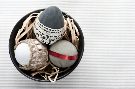 Easter eggs in black pot on gray napkinの写真素材