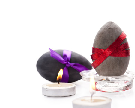 Black and grey Easter eggs and two candlesの写真素材