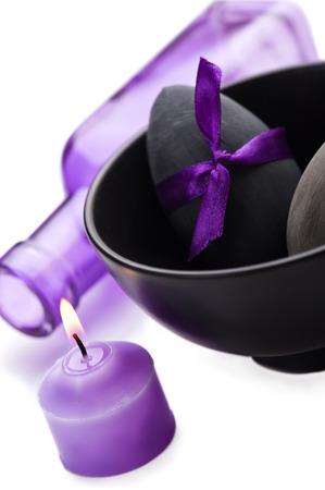 Black Easter egg with purple bow, bottle and candleの写真素材