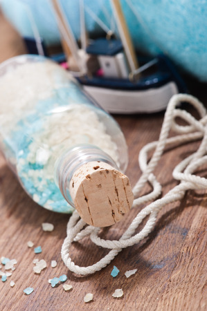 Still life of the mix of bath salts, nautical rope and toy shipの写真素材