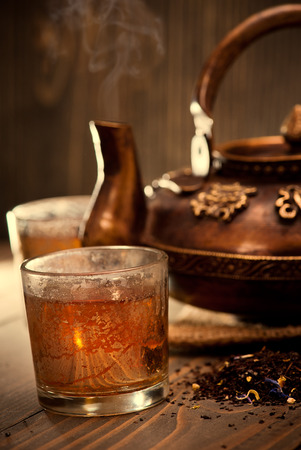 Antique iron hot tea pot fuming on dark wooden backgroundの写真素材