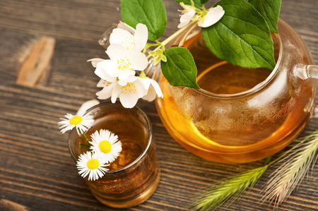 Jasmine tea in a glass tea pot on dark brown wooden background の写真素材