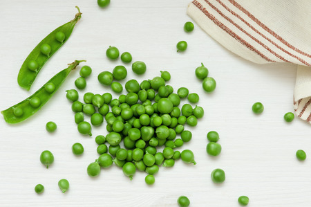 Close-up of green peas on white wooden backgroundの写真素材