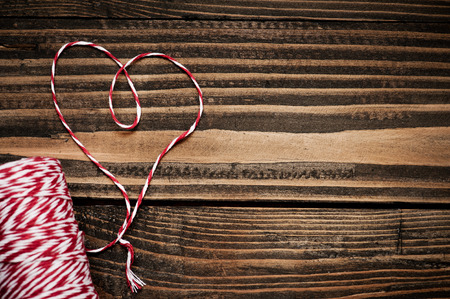 Heart shape made with twine on a dark wooden background. Vintage style. の写真素材