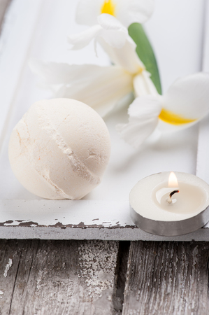SPA still life, vanilla bath bomb closeup lit candles on wooden backgroundの写真素材