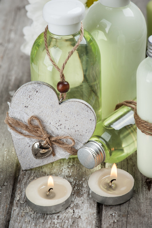 SPA still life, bath products, lit candles, wooden background, green grey, closeupの写真素材