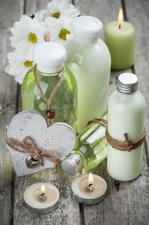SPA still life, bath products, lit candles, wooden background, green greyの写真素材