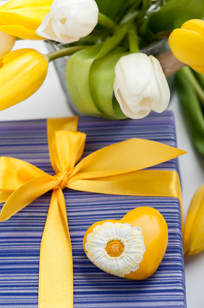 Purple gift box with yellow heart and ribbon, tulipsの写真素材