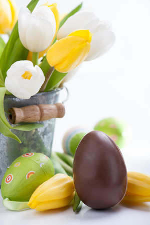 Chocolate and colorful Easter eggs and tulip flowersの写真素材