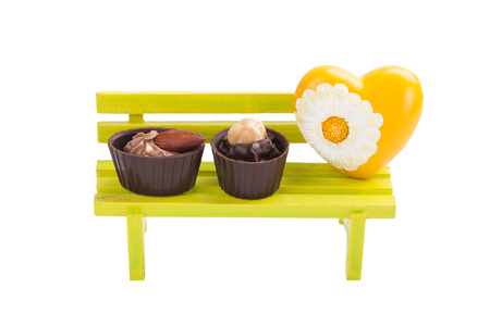 Apple green toy bench, chocolates and yellow heartの写真素材