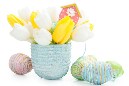 Pink Wooden Toy Bird House, Easter decoration. Tulips and easter eggs on backgroundの写真素材