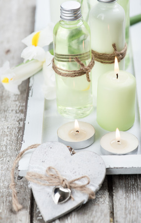 SPA still life, bath products, lit candles, wooden background, green greyの写真素材