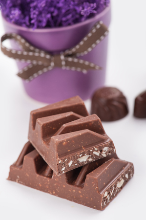 Chocolate bar close-up, with purple pot flowerの写真素材
