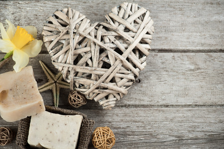 Spa background with rustic heart, organic soap, weathered wooden tableの写真素材