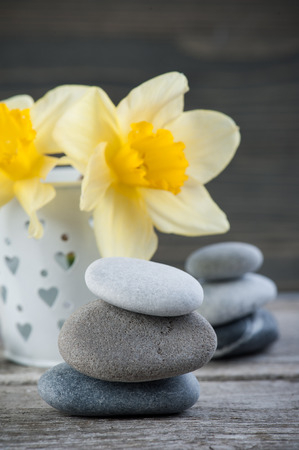 Balancing pebble stones and yellow flowers, ZEN Stone Garden on wooden background, spa tranquil scene conceptの写真素材