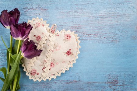 Purple tulips bunch and textile heart on old blue red wooden background. Space for text.の写真素材