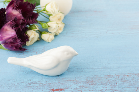 Purple tulips bunch and decorative bird on old blue red wooden background. Space for text.の写真素材
