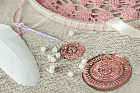DIY composition of handmade dream cathcer assembling. White feathers, pearls, pink beads and threadsの写真素材
