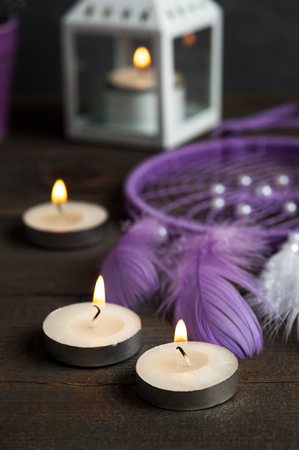 Purple dream catcher on wooden background with lit candles.  Zen decor still lifeの写真素材