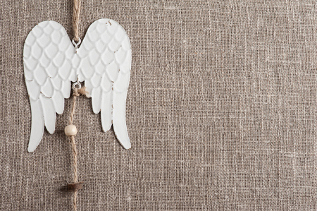 Linen background with christmas decoration. Angel wings toy. Wedding, xmas rough texture flat layの写真素材