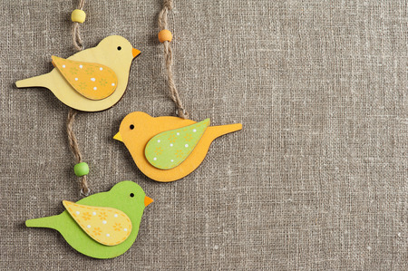 Linen background with three wooden birds. Wedding, family, rough texture flat layの写真素材