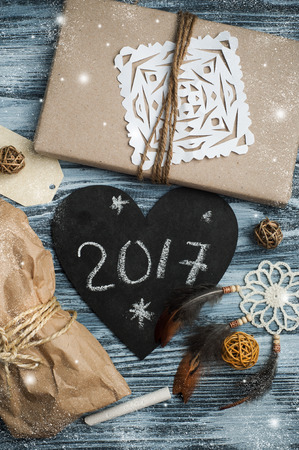 Flat lay background with christmas gift, dream catcher, tag and decoration on wooden background. Craft wrapping. View from aboveの写真素材