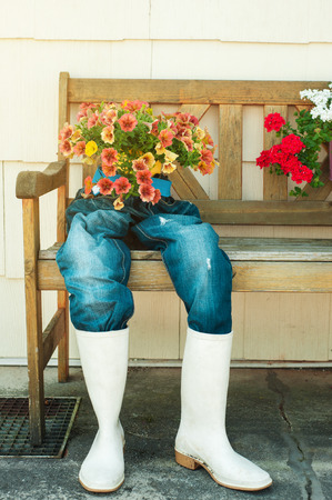 House facade decoration with old blue jeans used as flower potsの写真素材