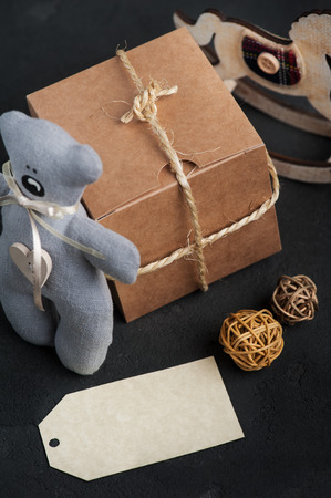 Christmas gifts on concrete background. Blank tag, teddy bear, decoration. Birthday or xmas presentの写真素材