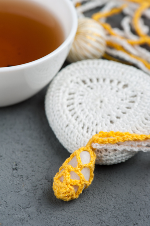 Cup of black tea and crocheted pebbles closeup on concrete background. Zen and mindfulness conceptの写真素材