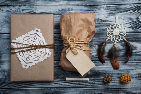 Christmas gifts on wooden background. Craft wrapping and dream catcher decoration. View from aboveの写真素材