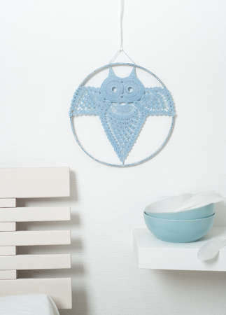 Blue dream catcher crocheted owl in the interior with blue bowlsの写真素材
