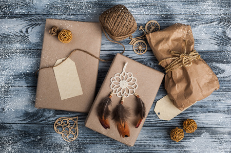 Christmas gifts on wooden background. Craft wrapping and dream catcher decoration. View from aboveの写真素材