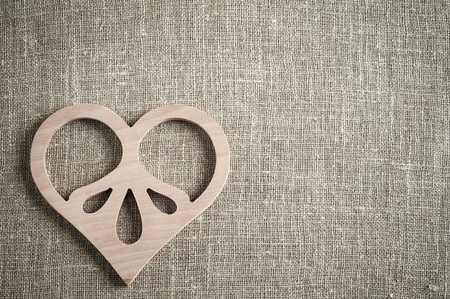 Linen background with wooden heart. Wedding, xmas rough texture flat layの写真素材