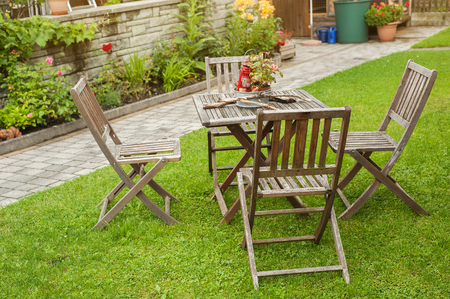 Wooden table and chairs standing on a lawn in the garden.の写真素材