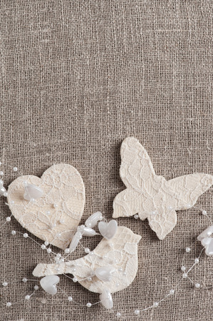 Linen background with wedding decoration. White butterfly, heart, bird. Wedding, xmas rough texture flat layの写真素材