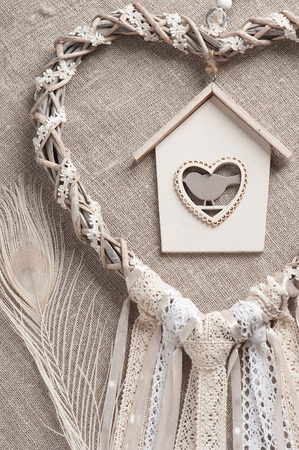 Beige lace heart shaped dream catcher with bird house. Wedding decor backgroundの写真素材