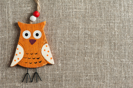 Linen background with wooden owl. Wedding, family, rough texture flat layの写真素材