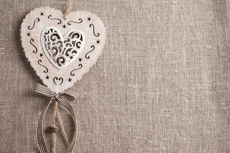 Linen background with christmas decoration. Wooden hearts. Wedding, xmas rough texture flat layの写真素材
