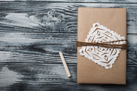 Flat lay background with christmas gift, heart and chalk on wooden background. Craft wrapping. View from aboveの写真素材