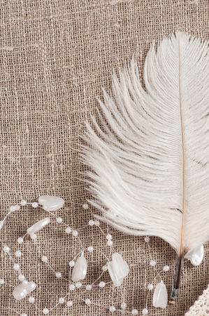 Linen background with wedding decoration. White feather. Wedding, xmas rough texture flat layの写真素材