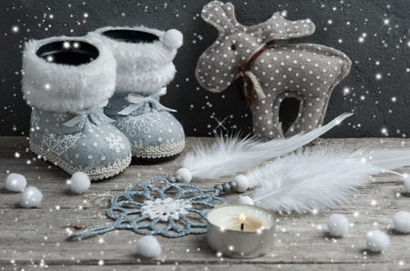 Silver Christmas decorations, dream catcher and lit candle on wooden background with snow.の写真素材