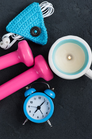 Good morning flat lay with blue alam clock, pink dumbbells and cord holder for earphones. Top viewの写真素材