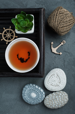Cup of black tea and crocheted pebbles closeup on concrete background. Zen and mindfulness conceptの写真素材