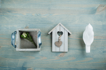 Flat still life. Wooden bird house, rose on blue shabby chic backgroundの写真素材